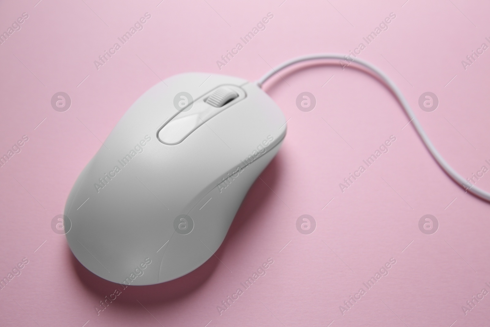 Photo of One wired mouse on pink background, closeup