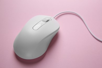 One wired mouse on pink background, closeup