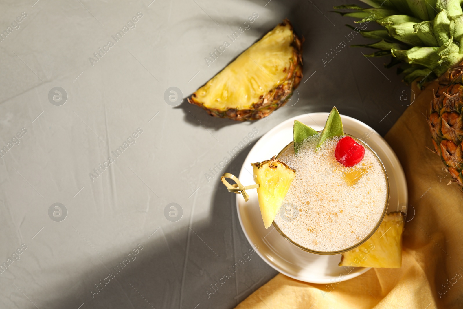 Photo of Tasty pineapple cocktail and fresh fruit on light grey table, flat lay. Space for text