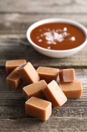 Photo of Yummy caramel candies on wooden table, closeup