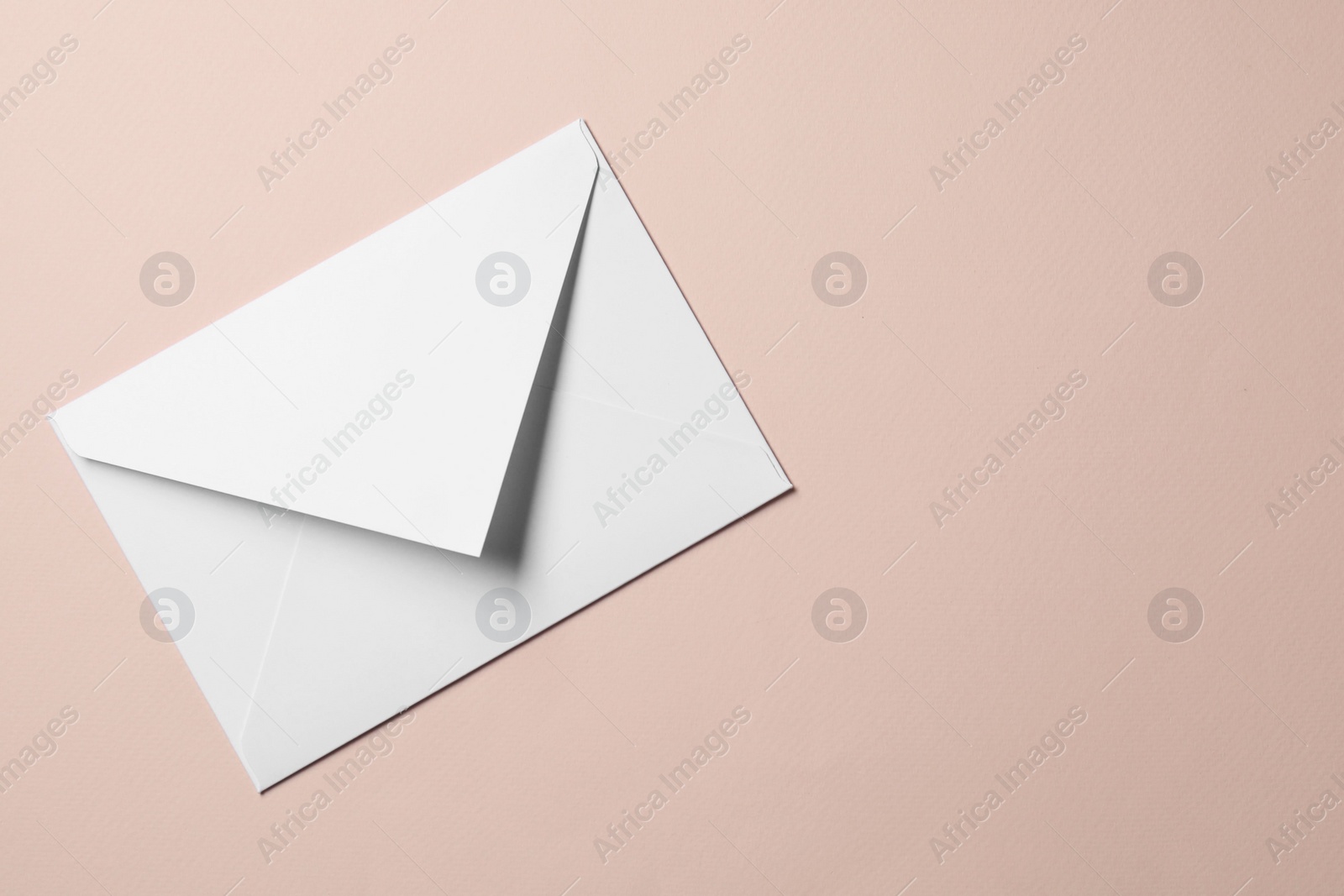 Photo of Letter envelope on beige background, top view. Space for text