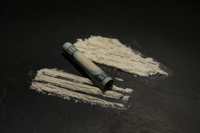 Photo of Drug addiction. Cocaine and rolled dollar banknote on grey textured table, closeup