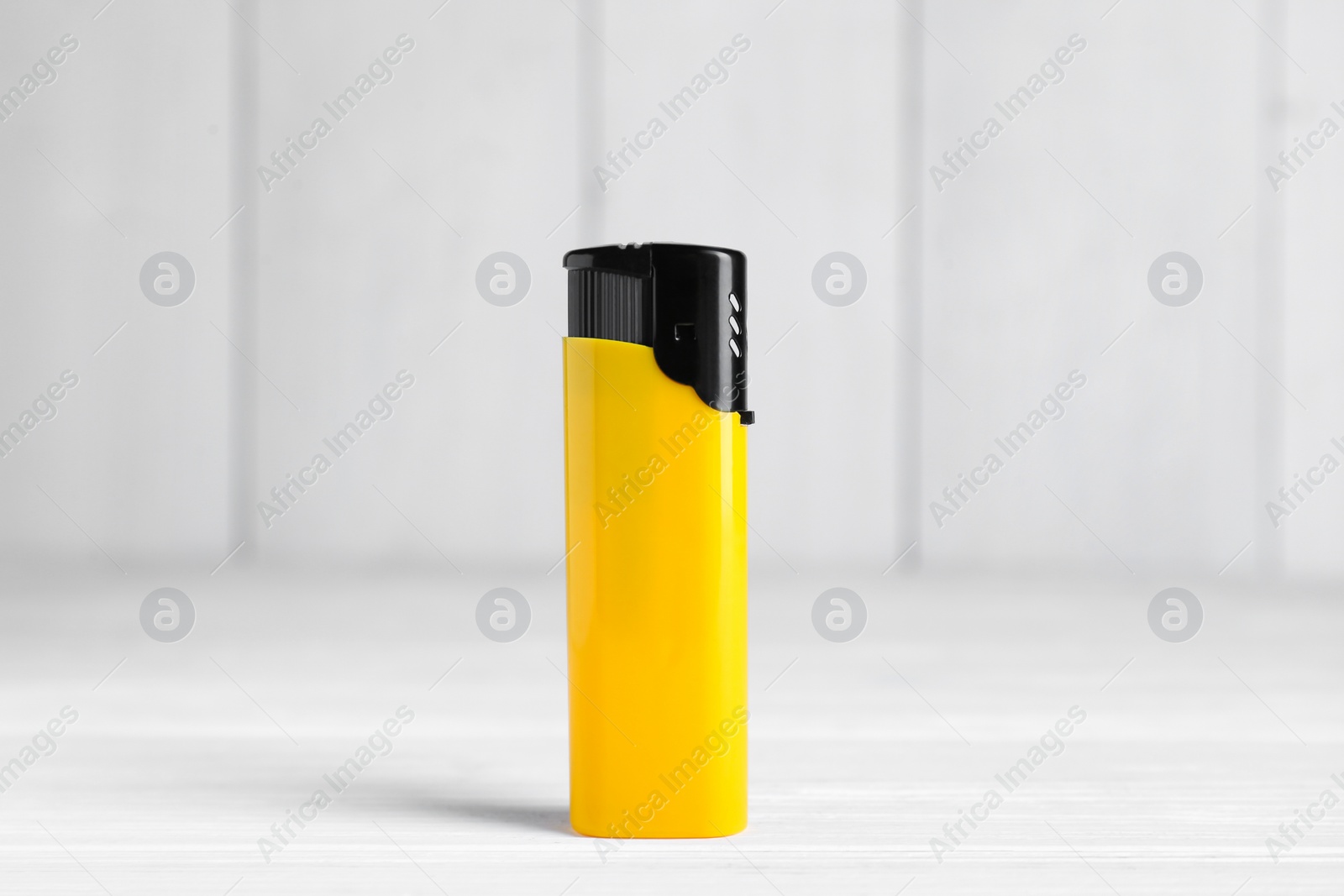 Photo of Stylish small pocket lighter on white wooden table