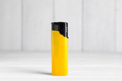 Photo of Stylish small pocket lighter on white wooden table