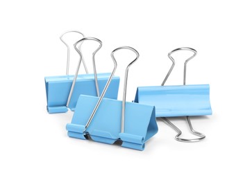 Photo of Light blue binder clips on white background. Stationery