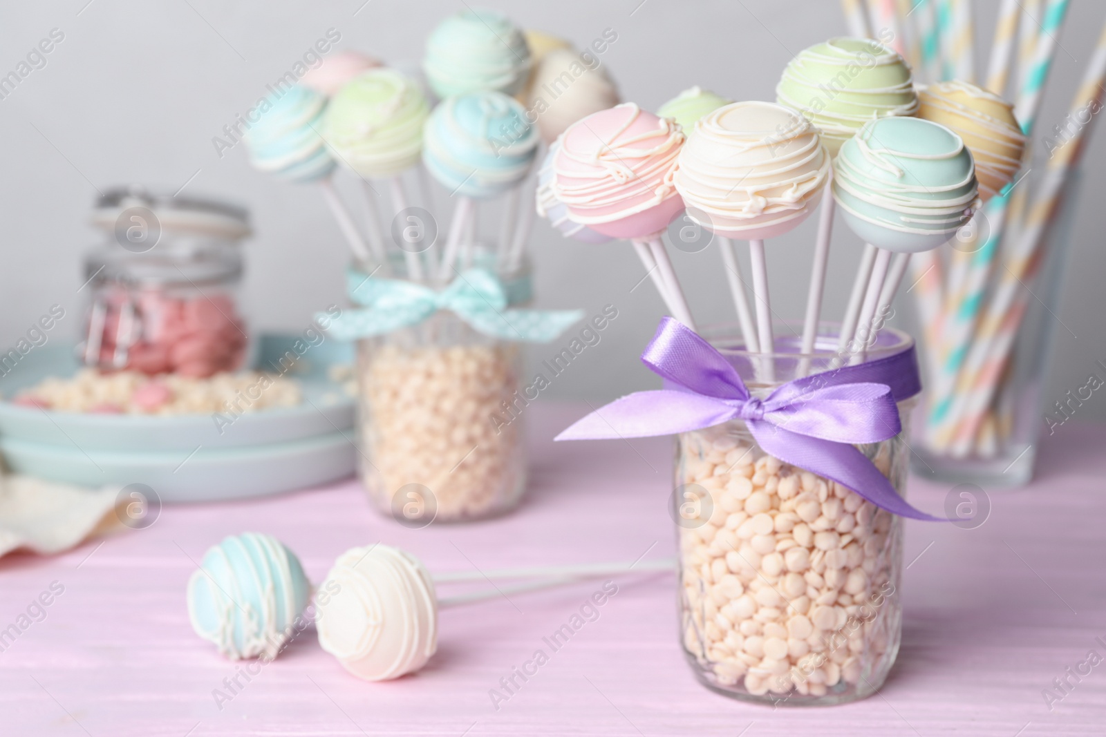 Photo of Sweet cake pops on pink wooden table. Space for text