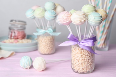 Photo of Sweet cake pops on pink wooden table. Space for text