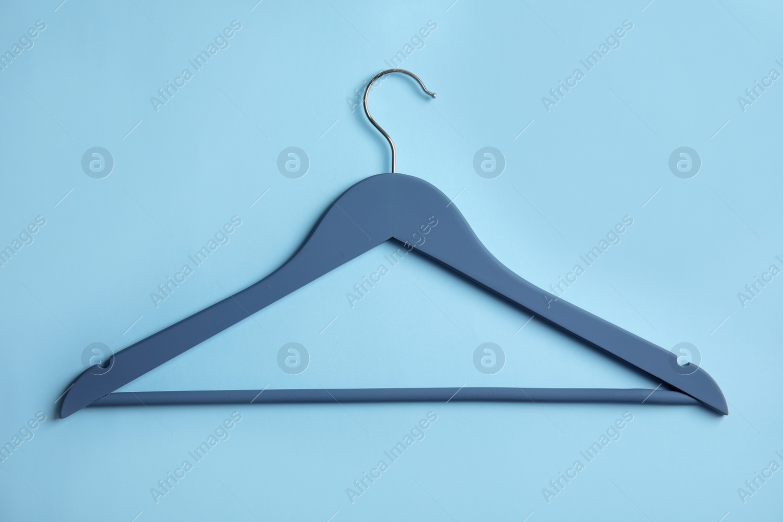 Photo of Empty wooden clothes hanger on color background, top view