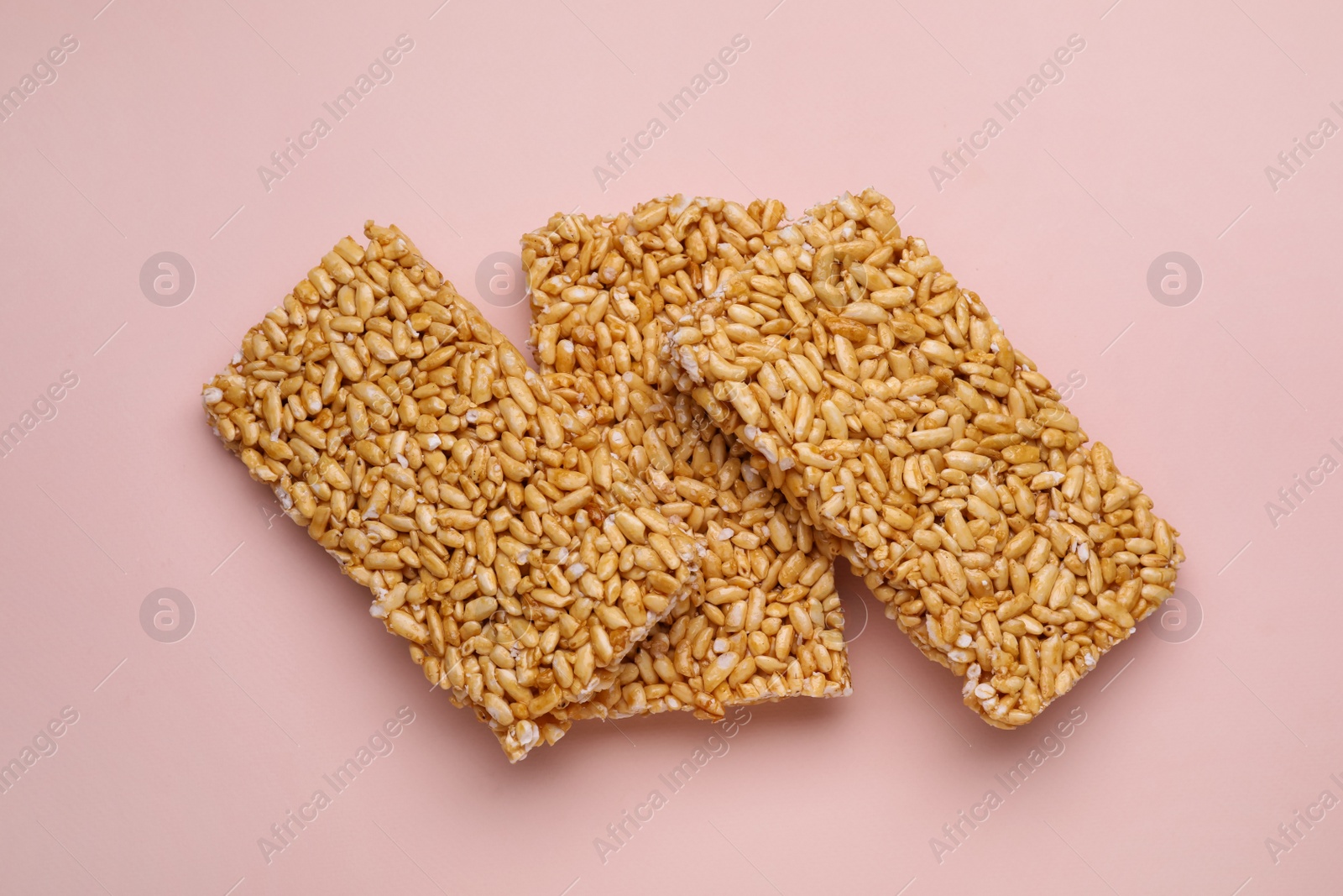 Photo of Puffed rice bars (kozinaki) on pale pink background, top view