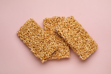 Puffed rice bars (kozinaki) on pale pink background, top view