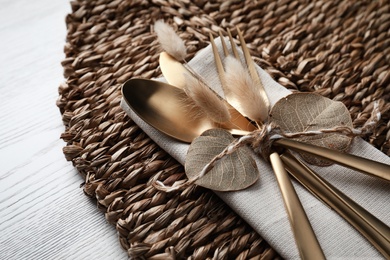 Photo of Cutlery wicker mat on white background, closeup. Autumn table setting