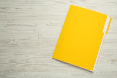 Photo of Yellow file with documents on white wooden table, top view. Space for text