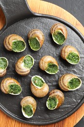 Photo of Delicious cooked snails on grey table, top view