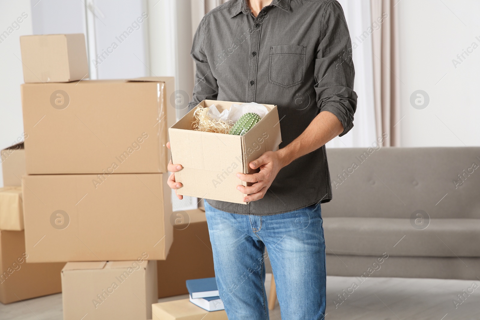 Photo of Man with moving box in his new house, closeup view