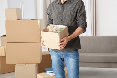 Man with moving box in his new house, closeup view