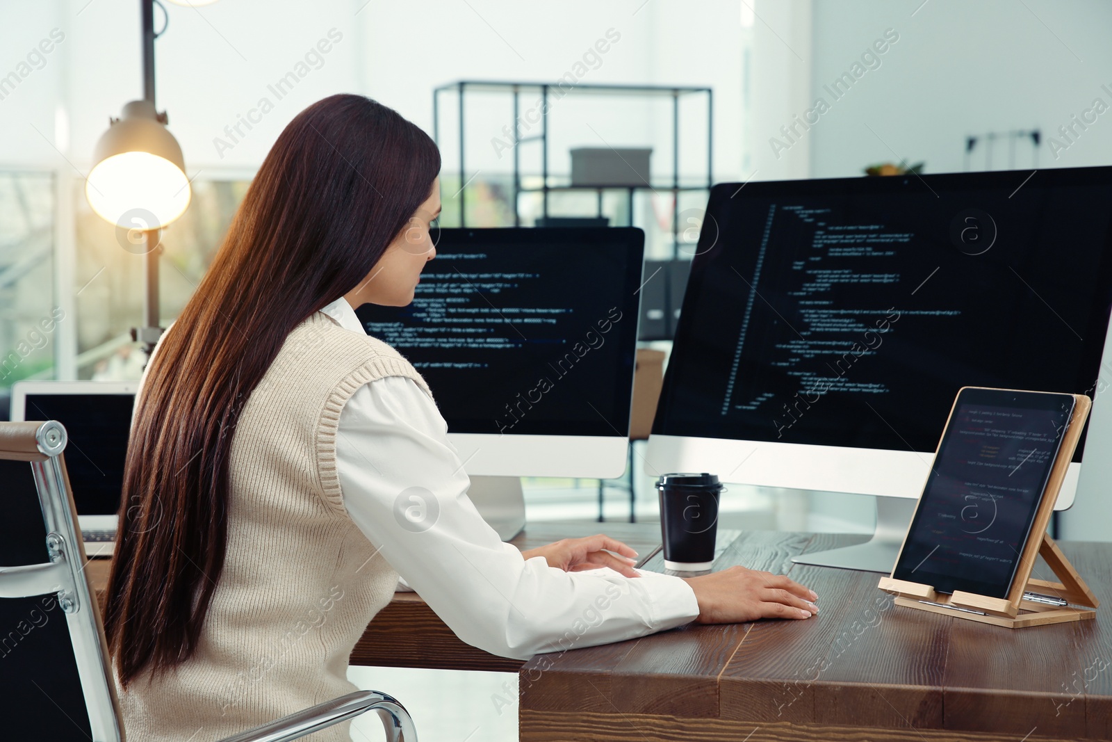 Photo of Programmer working at desk in modern office