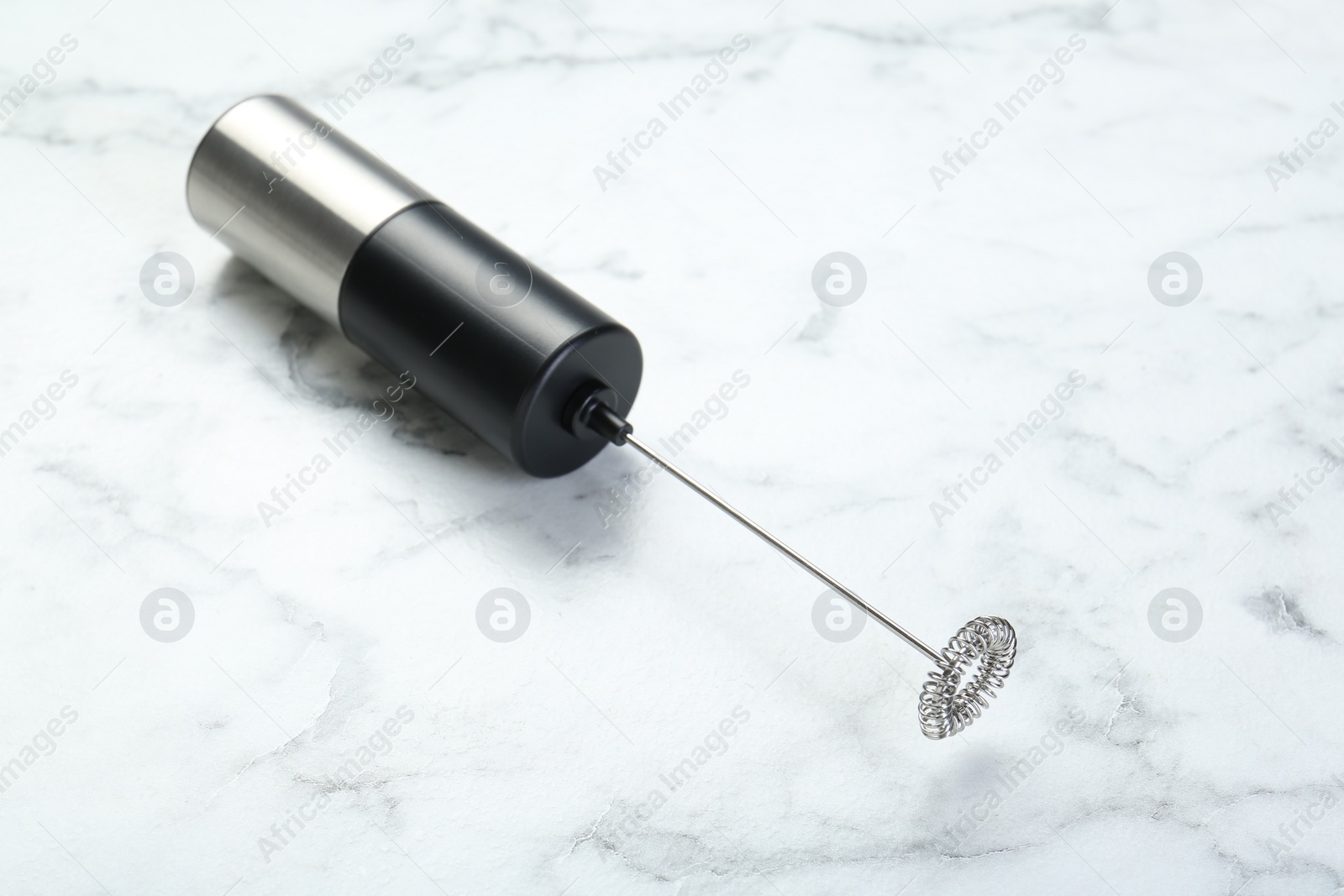 Photo of Black milk frother wand on white marble table