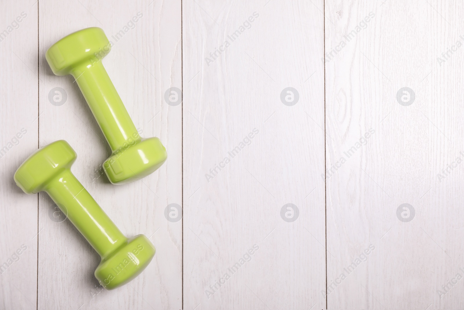 Photo of Vinyl dumbbells and space for text on wooden background, flat lay