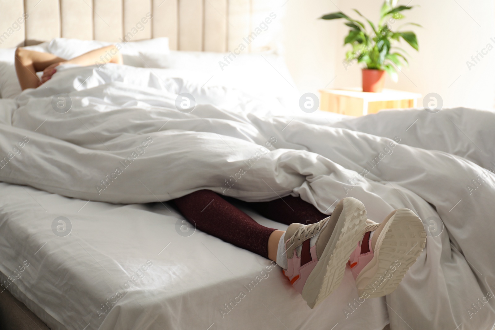 Photo of Lazy young woman sleeping on bed instead of morning training, closeup