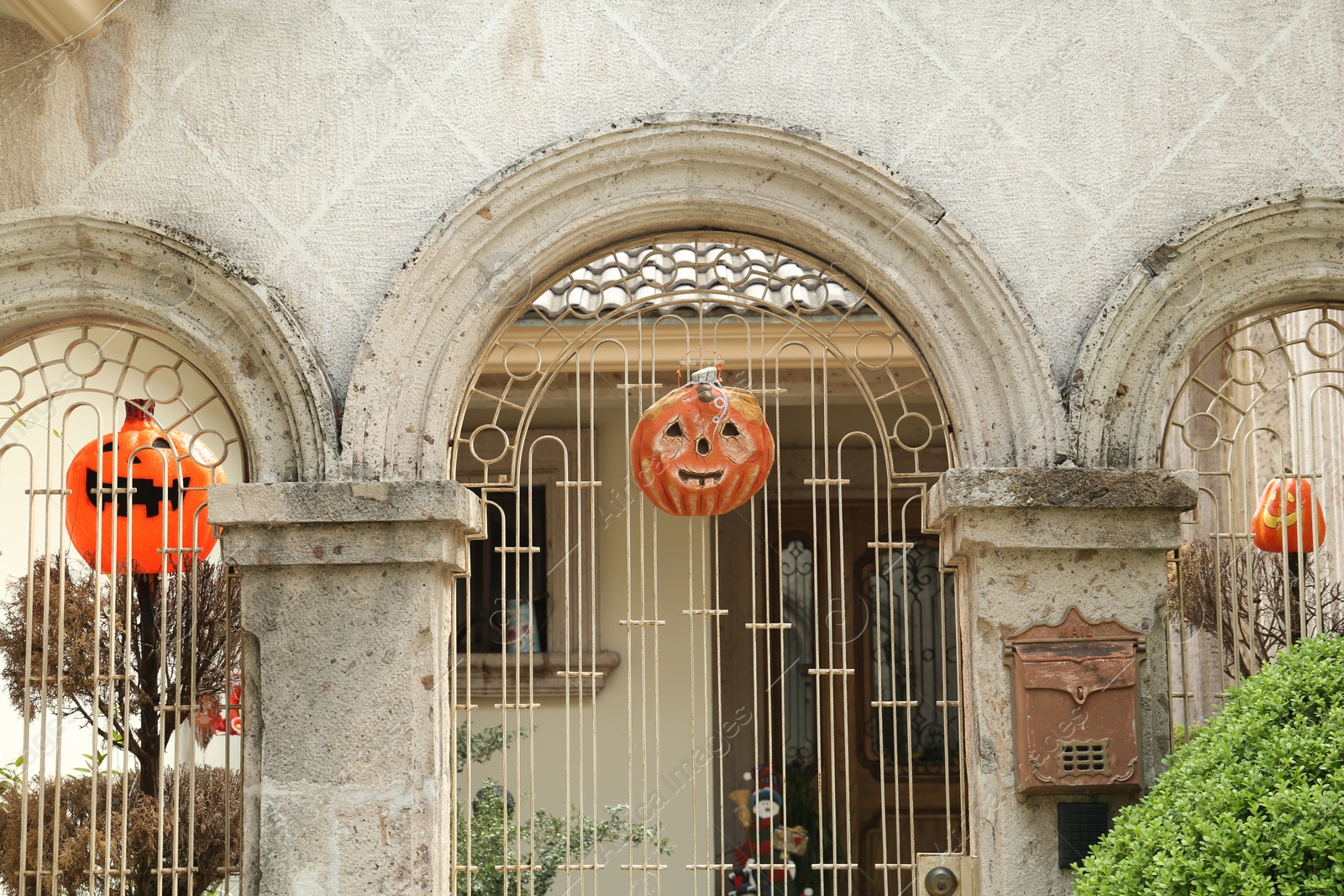 Photo of Pumpkin lanterns on white fence outdoors. Halloween decoration