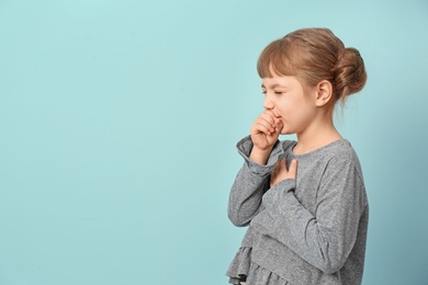 Photo of Little girl coughing on color background