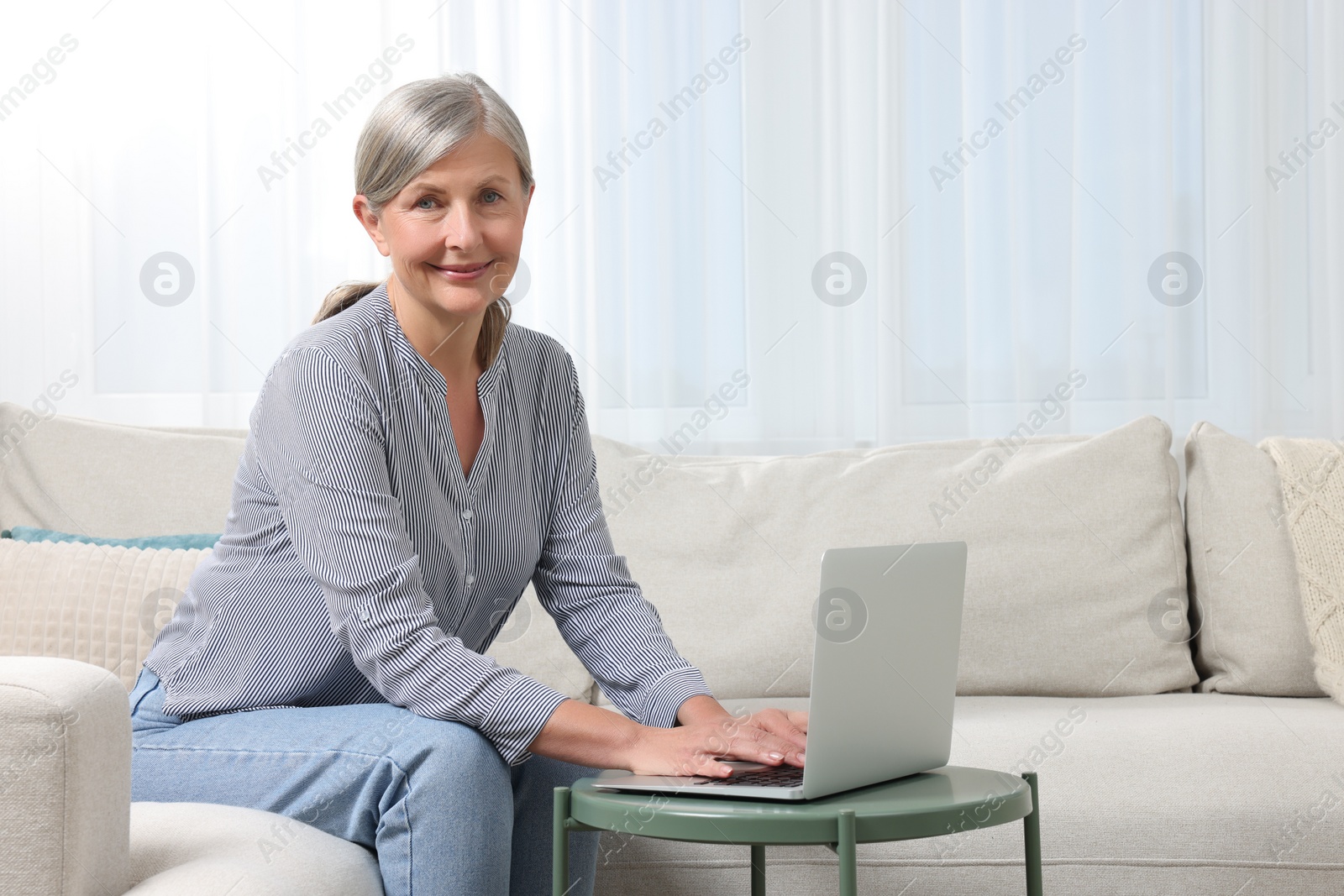 Photo of Beautiful senior woman using laptop at home