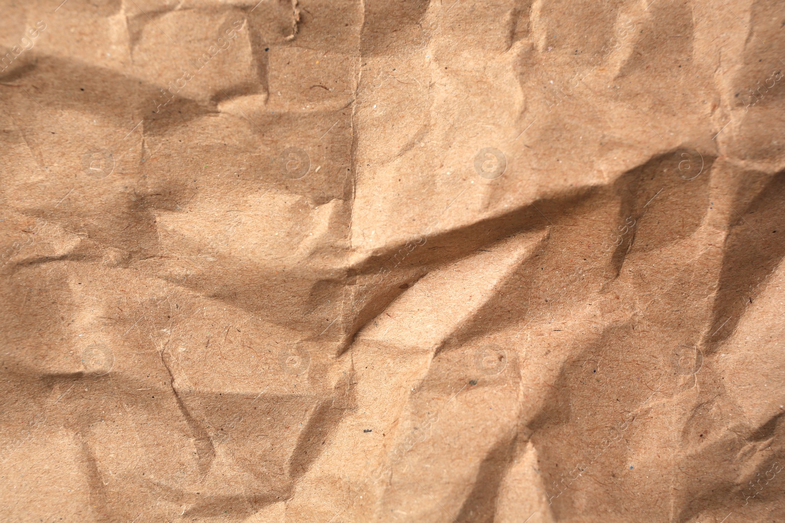 Photo of Sheet of crumpled kraft paper as background, top view