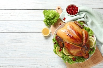 Photo of Delicious roasted turkey on wooden table, top view. Space for text