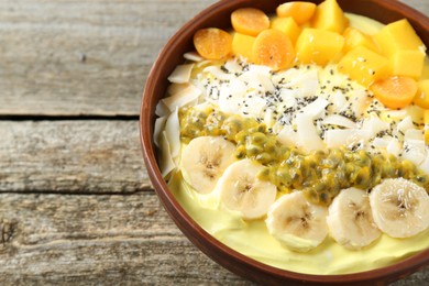 Photo of Tasty smoothie bowl with fresh fruits on wooden table, closeup. Space for text