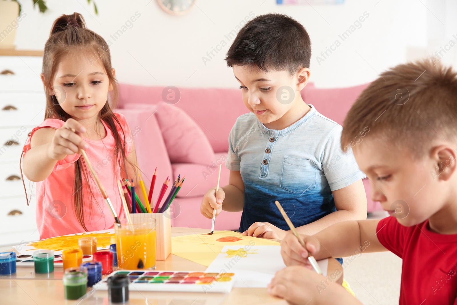 Photo of Cute little children painting at table in playing room