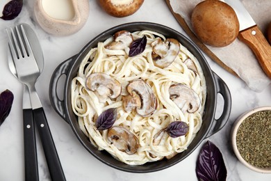 Photo of Delicious pasta with mushrooms served on white table, flat lay