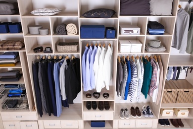 Photo of Large wardrobe with different clothes, home stuff and shoes