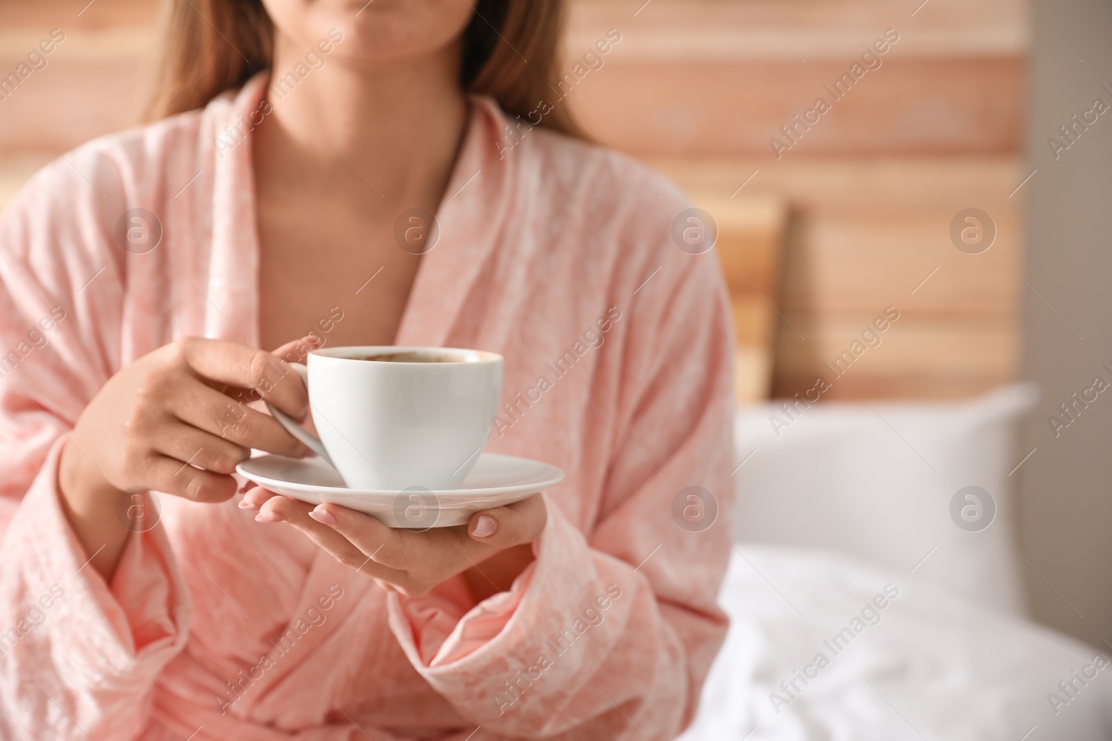 Photo of Woman with cup of hot coffee at home, closeup