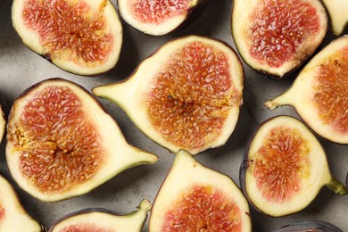 Delicious cut raw figs on light grey table, flat lay