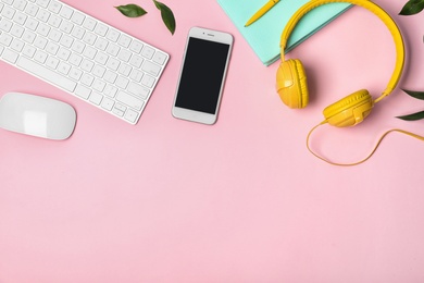 Flat lay composition with smartphone, computer keyboard and headphones on color background. Space for text