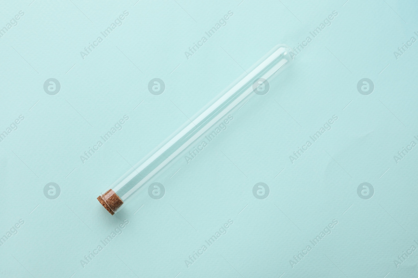 Photo of Test tube on turquoise background, top view. Laboratory glassware