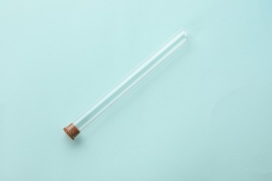 Photo of Test tube on turquoise background, top view. Laboratory glassware