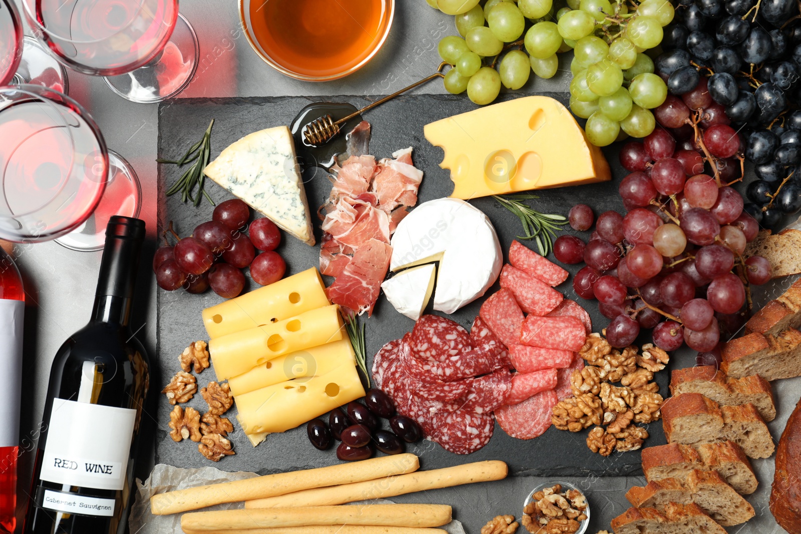 Photo of Flat lay composition with wine and snacks on grey background