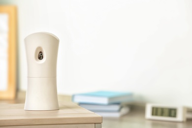 Photo of Automatic air freshener on table in room