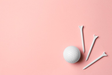 Photo of Golf ball and tees on pink background, flat lay. Space for text