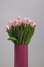 Beautiful bouquet of fresh pink tulips on light grey background