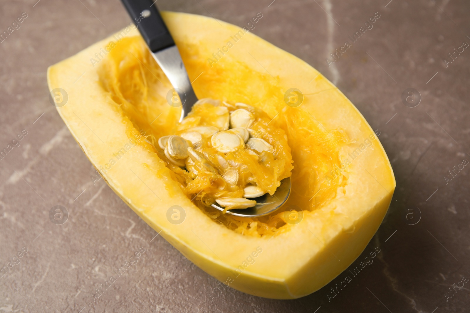 Photo of Cut spaghetti squash and spoon on gray table