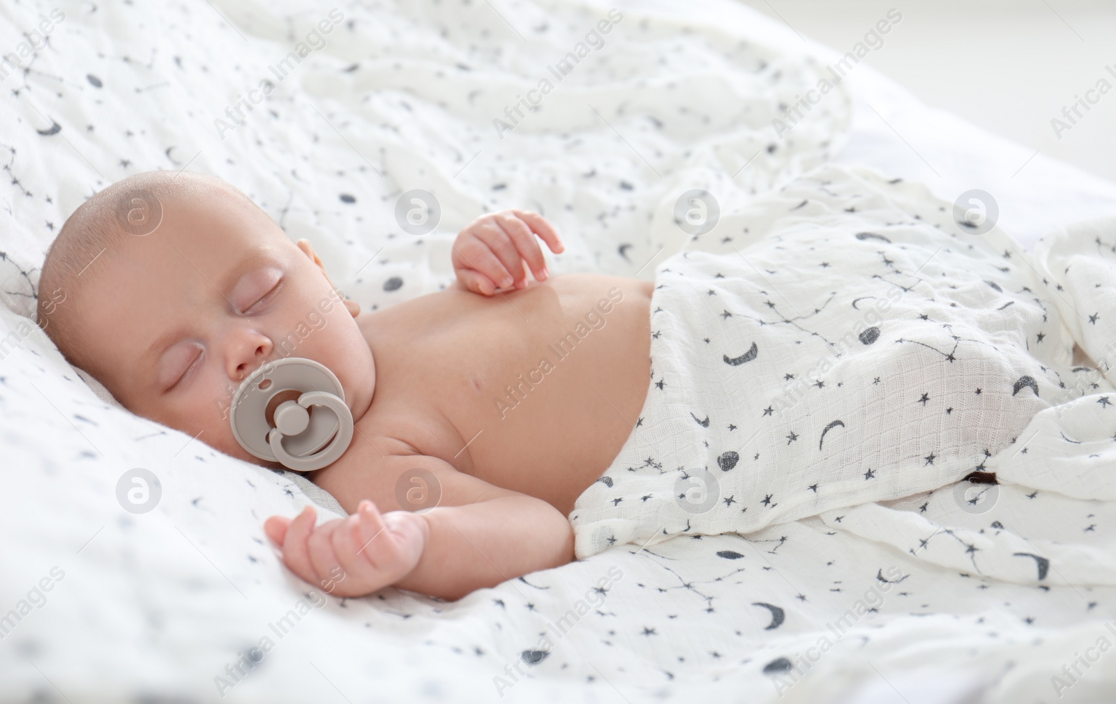 Photo of Cute little baby with pacifier sleeping on bed