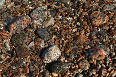 Beautiful pebbles in sea water as background, top view