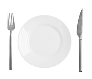 Photo of Clean plate and shiny cutlery on white background, top view