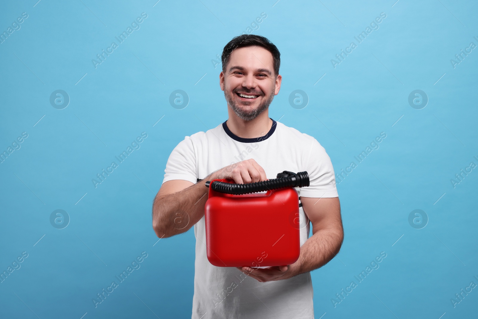 Photo of Man holding red canister on light blue background