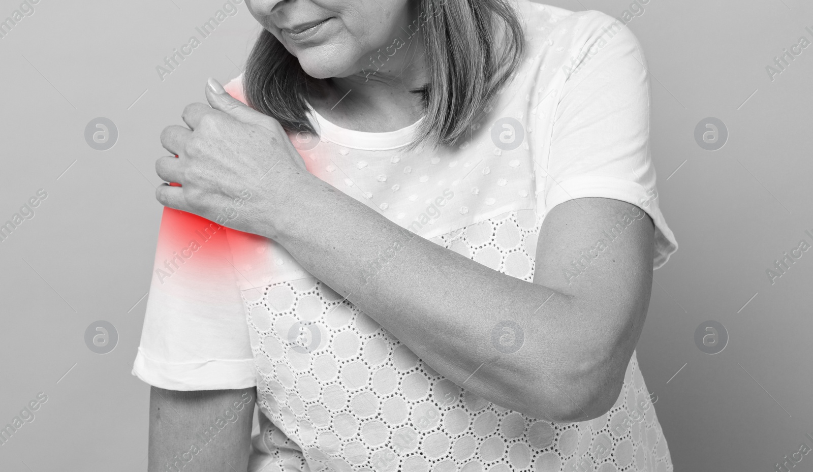 Image of Woman suffering from pain in shoulder, closeup. Black and white effect. Banner design