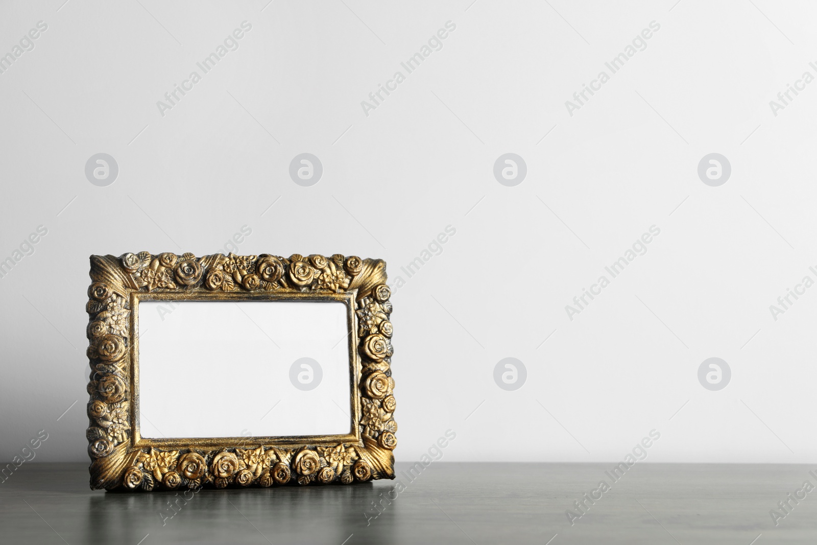 Photo of Beautiful vintage empty frame on wooden table, space for text