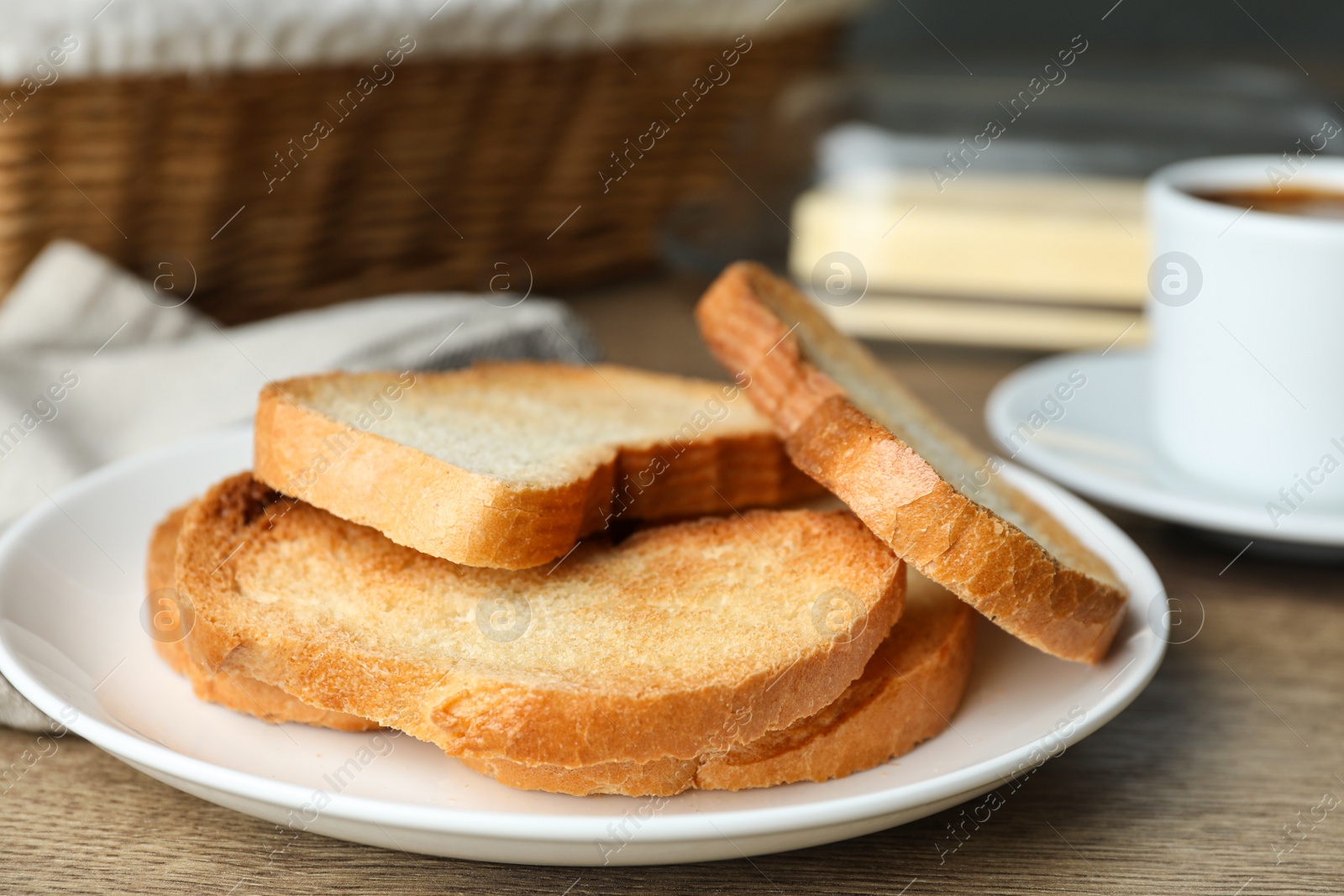 Photo of Plate with toasted bread on wooden table, closeup