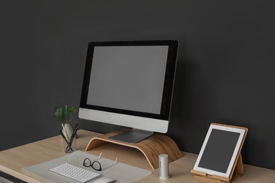 Photo of Modern workplace interior with computer on table. Space for text